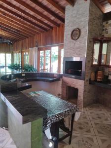 皮拉西卡巴Sítio refúgio do lago的客厅设有石制壁炉和桌子。