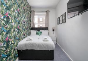 伦敦Private Studio Unit in Chapel Market London的一间卧室配有一张带花卉墙壁的床