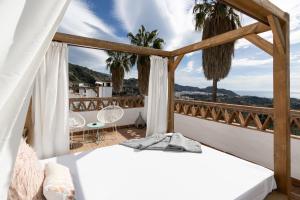弗里希利亚纳Posada Morisca Charming Hotel Boutique的一间卧室,享有棕榈树阳台的景色