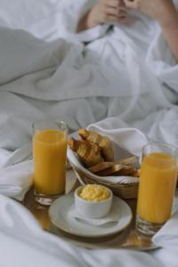 新德里Hotel Samara Kingdom Near Delhi Airport的早餐盘,包括一盘食物和两杯橙汁