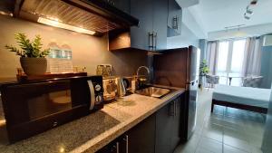 马尼拉ELUDE Designer Suite Pasig - Prime Location的厨房配有水槽和微波炉