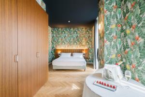 米兰Collini Rooms的一间卧室配有一张带花卉壁纸的床