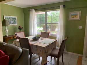 萨拉索塔Cozy Cottage near Beaches and Downtown Sarasota的一间带桌椅和窗户的用餐室
