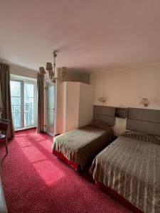 巴黎圣皮埃尔酒店的酒店客房,配有两张床和粉红色的地毯