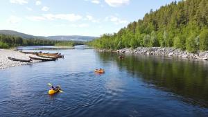 阿尔塔Sorrisniva Arctic Wilderness Lodge的一群人划着皮艇在河上