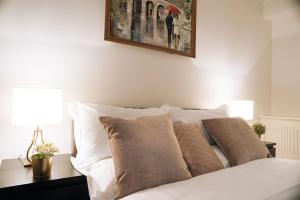 伦敦Curzon Residences的一张带枕头的白色床和墙上的照片