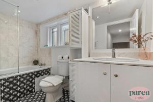 伦敦Parea Living - South Kensington, Elegant 1-Bedroom Flat, WFH Desk的白色的浴室设有卫生间和水槽。