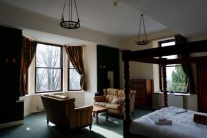 斯特灵Broomhall Castle Hotel的一间卧室配有一张床、一把椅子和窗户。