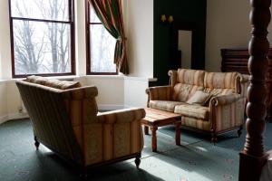 斯特灵Broomhall Castle Hotel的客厅配有两把椅子和一张沙发