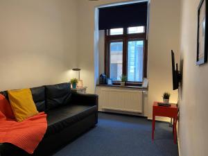 克拉科夫Millenium Apartments的客厅配有黑色沙发和窗户