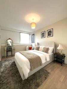 伦敦Amazing view 2 bedroom in Abbey Road的卧室设有一张白色大床和一扇窗户。