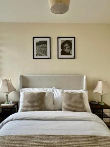 伦敦Amazing view 2 bedroom in Abbey Road的卧室配有一张墙上三幅照片的床