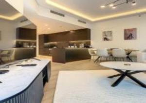 迪拜Key View - Marina Torch的一间带桌椅的客厅和一间厨房