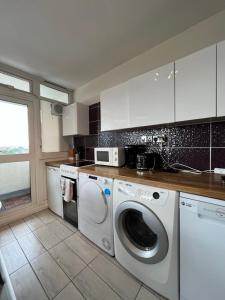 伦敦Amazing view 2 bedroom in Abbey Road的厨房配有洗衣机和烘干机
