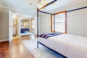奥斯汀Slaughter Creek Cottage的一间卧室配有一张床和吊扇