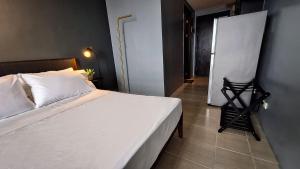 马尼拉ELUDE Designer Suite Pasig - Prime Location的卧室配有白色的床和墙上的绘画作品