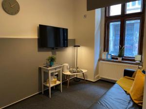 克拉科夫Millenium Apartments的客厅配有沙发和墙上的电视