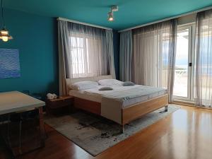 波尔Apartments Villa Azzurra Bol的一间卧室配有一张蓝色墙壁和窗户的床