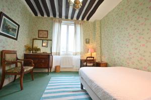 巴黎埃斯梅拉达酒店的一间卧室配有一张床、一张书桌和一个窗户。