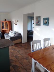 贝蒂湾Streams Cottage的客厅配有桌子和床。