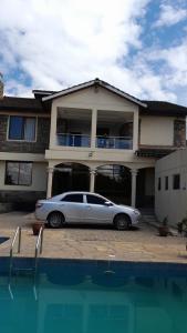 纳库鲁Twiga Whitehouse Villas的停在房子前面的银色汽车