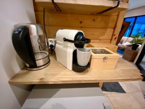 索斯特B&B Wellness Soest的咖啡壶,位于木柜台上,配有咖啡壶