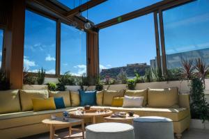雅典莲花酒店的客厅配有沙发、桌子和窗户