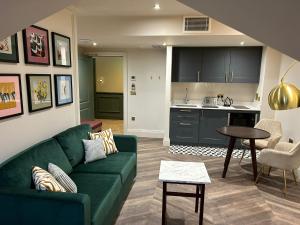 谢伯恩The Hillbrook Hotel & Spa - Sherborne的一间带绿色沙发的客厅和一间厨房