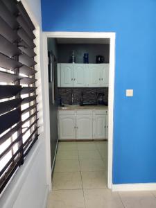 蒙特哥贝the Blue Ackee的厨房配有白色橱柜和蓝色的墙壁