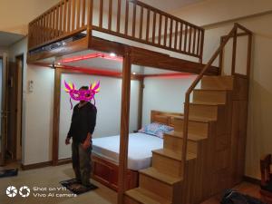 特雷塞马蒂雷斯Happy Stays C - The Queen's Loft at SMDC Hope Residences的戴面具的男人站在双层床上