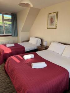 邓巴顿OYO Lochway Hotel的两张位于酒店客房的床,配有毛巾