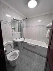邓巴顿OYO Lochway Hotel的浴室配有卫生间、盥洗盆和浴缸。