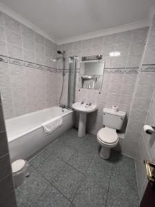 邓巴顿OYO Lochway Hotel的浴室配有卫生间、盥洗盆和浴缸。