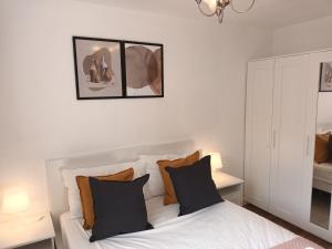 阿伯丁Spacious Elegant 2-BR Apartment in Aberdeen City Centre的一间卧室配有白色的床和黑色和橙色枕头。