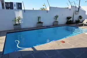 米德兰The Mansioners Apartment的一座白色墙壁的大型蓝色游泳池