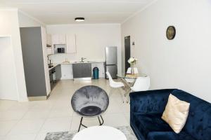 米德兰The Mansioners Apartment的一间带蓝色沙发的客厅和一间厨房