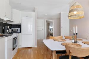 博登Guestly Homes - 1BR Cozy Apartment的厨房以及带白色桌椅的用餐室。