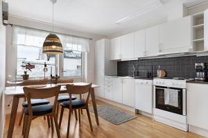 博登Guestly Homes - 1BR Cozy Apartment的厨房配有白色橱柜和桌椅