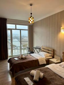 第比利斯Hotel Marioni的酒店客房设有两张床和大窗户。