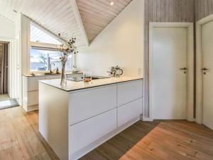 凡岛Holiday Home Ubbe - 800m from the sea in Western Jutland by Interhome的一间厨房,配有白色的橱柜和大窗户