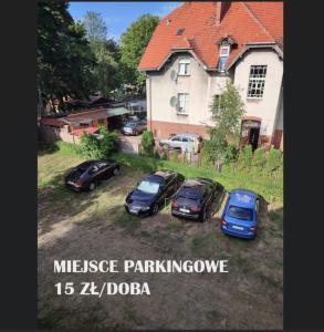 乌斯特卡Villa Kaszubska的停在房子前面的院子中的一群汽车