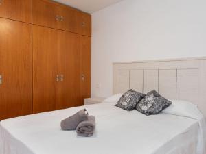 林孔-德拉维多利亚Apartment El apartamento de Noa by Interhome的一张带两个枕头的白色床和一只塞满动物的睡床