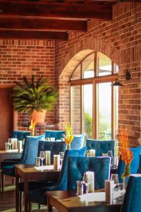 ChlʼabaPenzión Modrá ryba的一间设有蓝色椅子和砖墙的用餐室