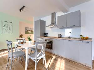 法扎纳Studio Zanet by Interhome的厨房配有白色橱柜和桌椅