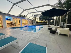 迈阿密Home in Miami的一个带椅子和遮阳伞的游泳池