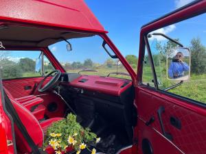 波尔蒂芒Rent a Blue Classics' s Campervan for your Road trip in Portimao -VOLKSWAGEN T3的把一张照片放在红色卡车镜子里的人