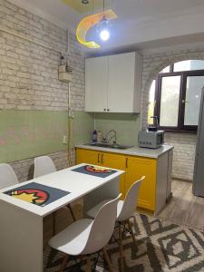 奇姆肯特Апартаменты的厨房配有桌椅和水槽。