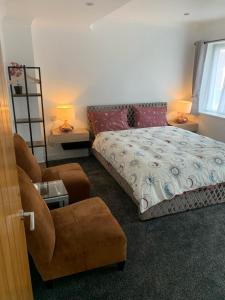 卢顿Luton Lodge - Near London Luton Airport Luxury Quite Rooms Close to Restaurants & Shops的一间卧室配有一张床、一把椅子和一张沙发