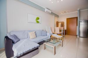 塞雷Apartment near the circuit of Serres and centre!!!的客厅配有蓝色的沙发和桌子