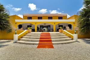 克拉伦代克Boutique Hotel Wanapa的黄色房子,楼梯上铺有红地毯